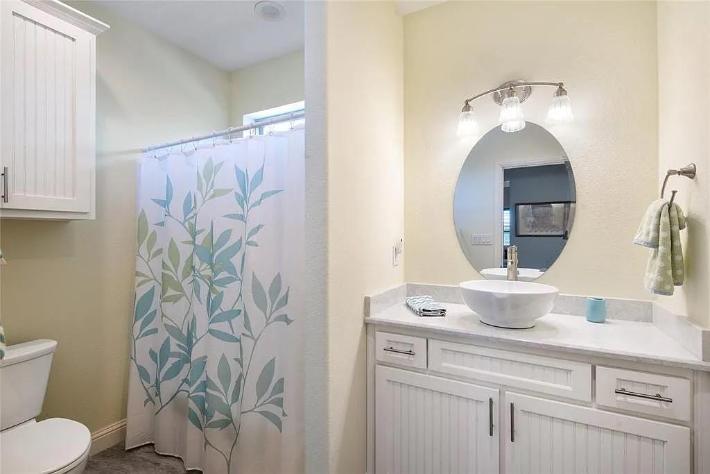 125 Heritage Road Gordonville, TX 76245 - Photo 33 of 40 a bathroom with a sink mirror and toilet