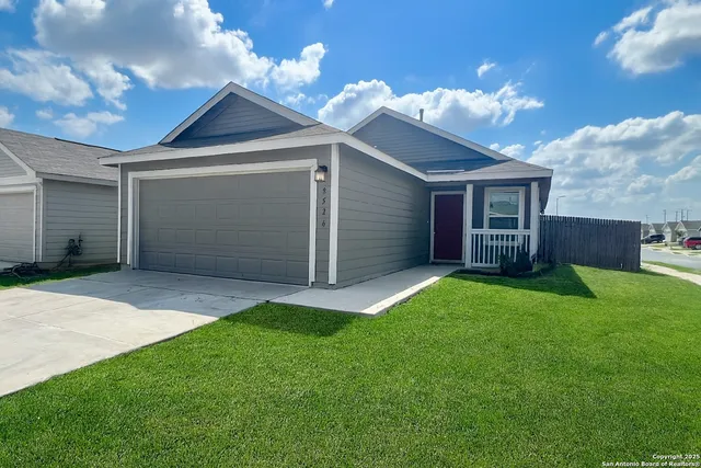 a front view of house with yard and garage