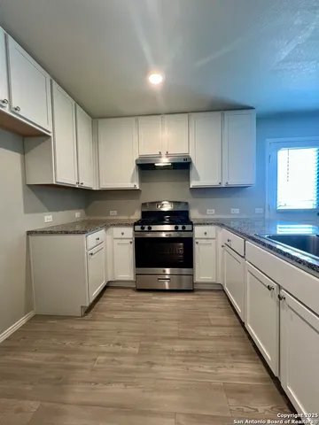 a kitchen with stainless steel appliances granite countertop a stove a sink and a microwave