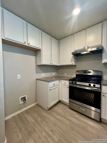a kitchen with appliances cabinets and a wooden floor