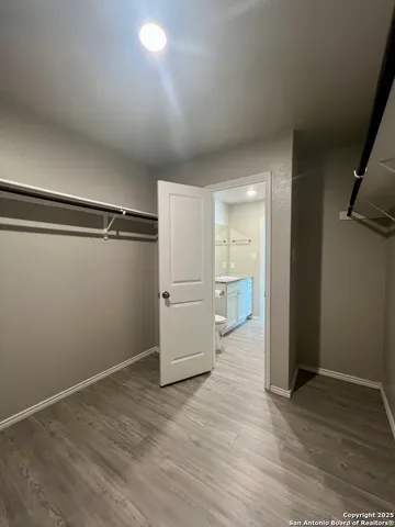 a view of a kitchen with a refrigerator and wooden floor