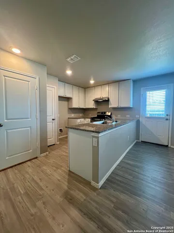 a kitchen with stainless steel appliances granite countertop a stove a sink and a refrigerator