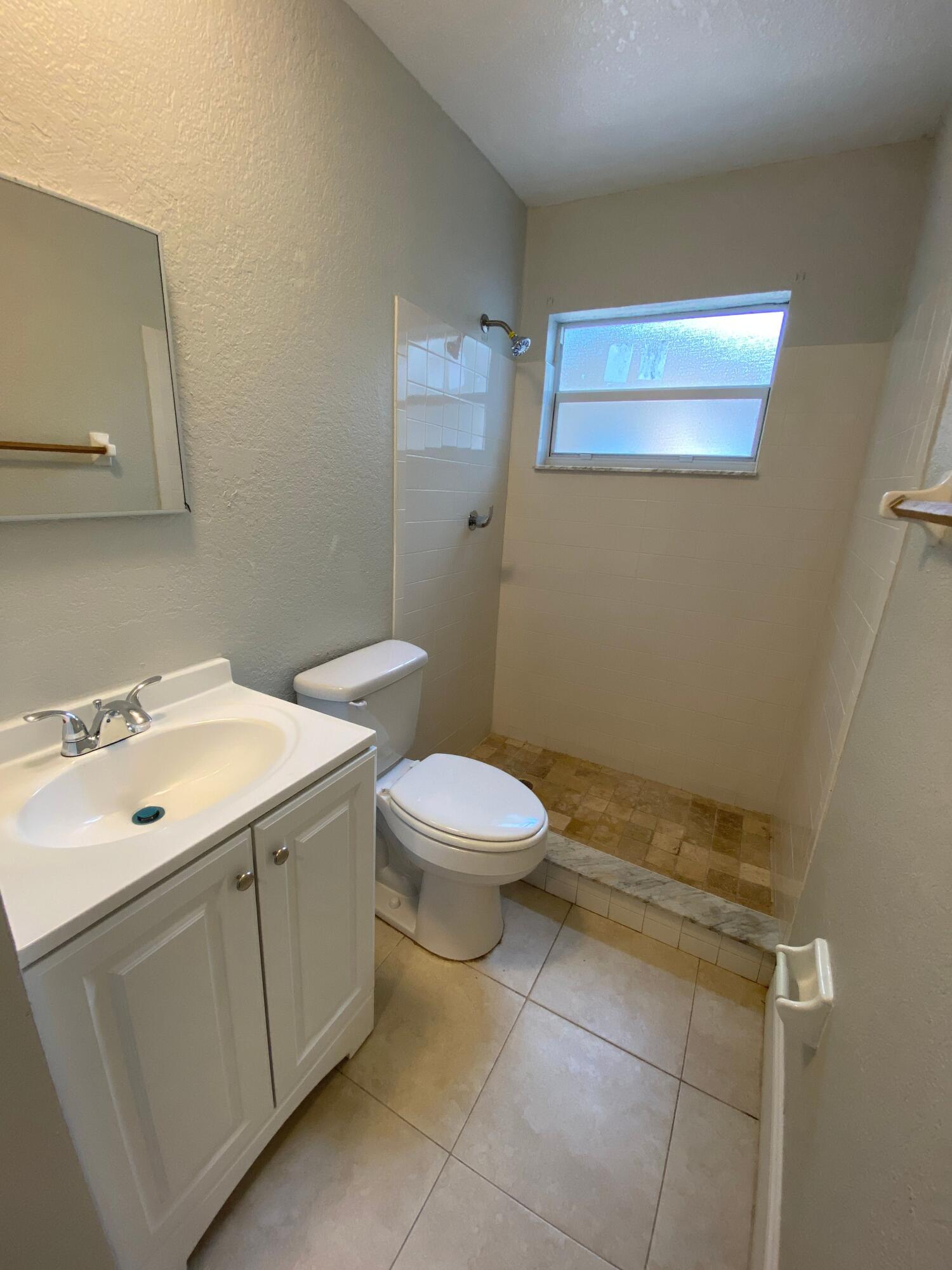 4327 Cocoanut Road West Palm Beach, FL 33406 - Photo 15 of 24 a bathroom with a sink a toilet and a mirror