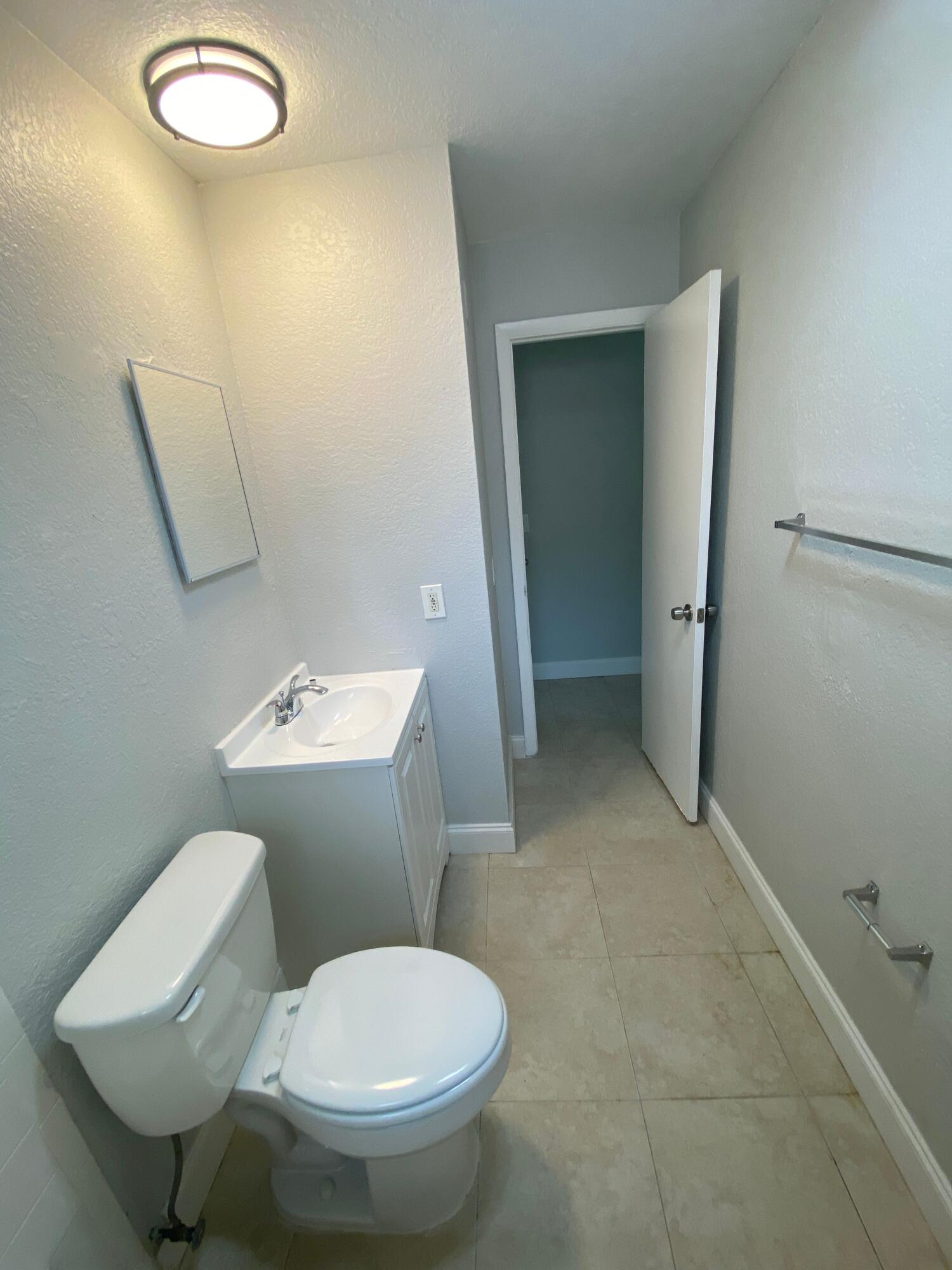 4327 Cocoanut Road West Palm Beach, FL 33406 - Photo 20 of 24 a bathroom with a toilet sink and mirror