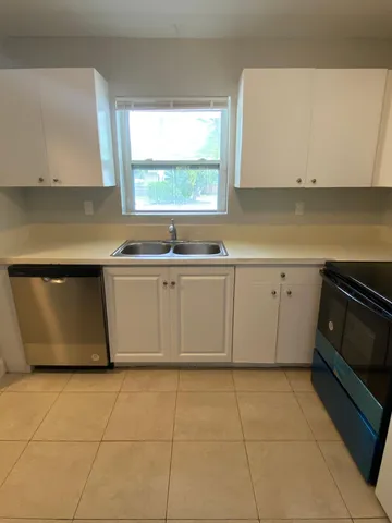 a kitchen with a sink a stove top oven and window