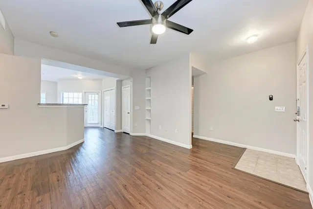 a view of a kitchen with wooden floor and a ceiling fan