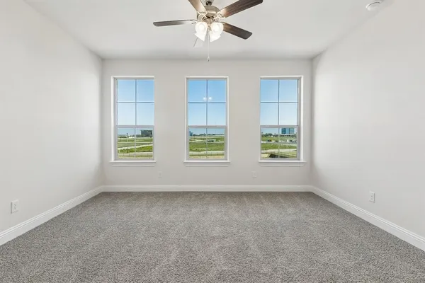 an empty room with chandelier fan