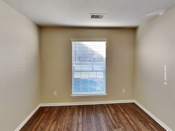 a view of a room with wooden floor and a window