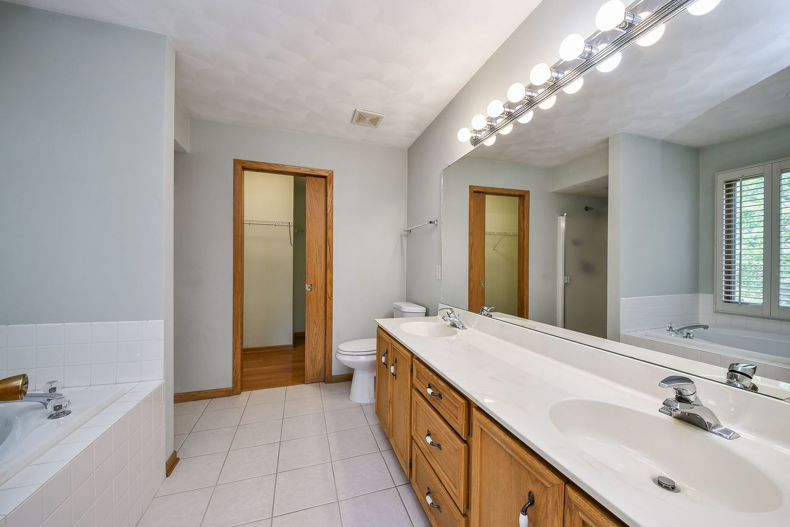 2917 Prairie Road Belvidere, IL 61008 - Photo 13 of 23 a spacious bathroom with a double vanity sink a large mirror and a bathtub