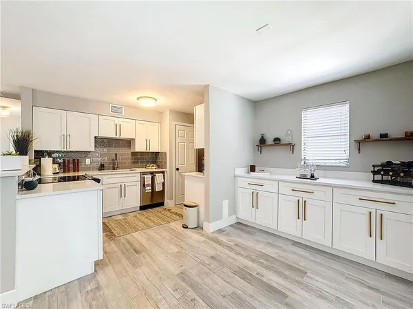 a kitchen with white cabinets sink and stainless steel appliances