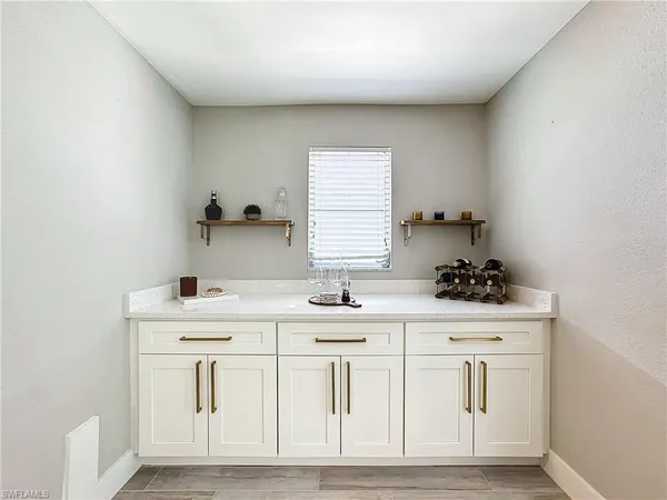 a kitchen with white cabinets and sink