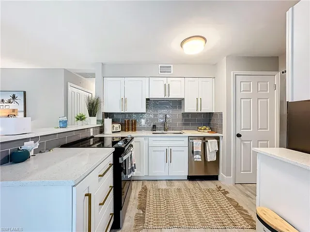 a kitchen with a sink a stove cabinets and a refrigerator