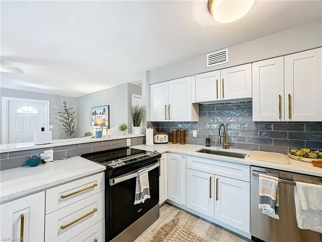a kitchen with a sink stove top oven and cabinets