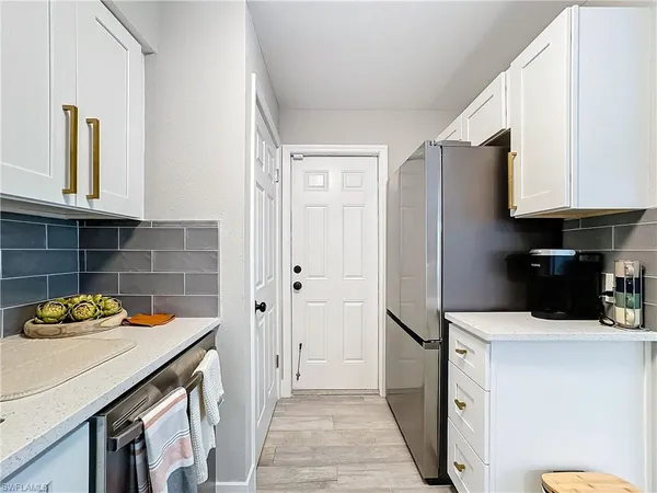 a kitchen with stainless steel appliances a refrigerator sink and cabinets