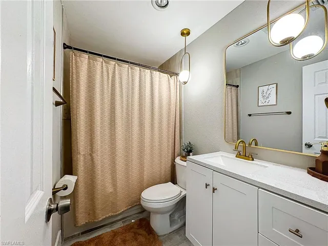 a bathroom with a sink a toilet and shower curtain