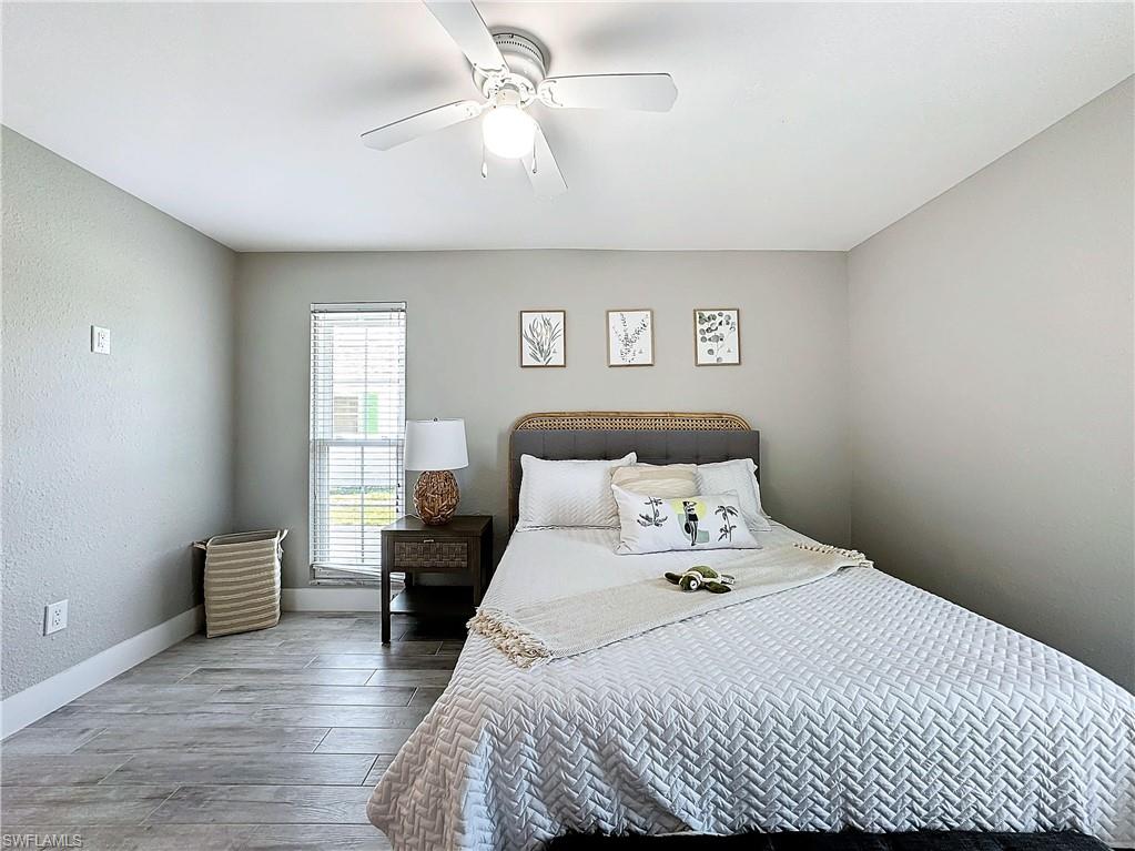 9 Knights Bridge Road, Unit 30 Naples, FL 34112 - Photo 35 of 47 a bedroom with a bed and wooden floor