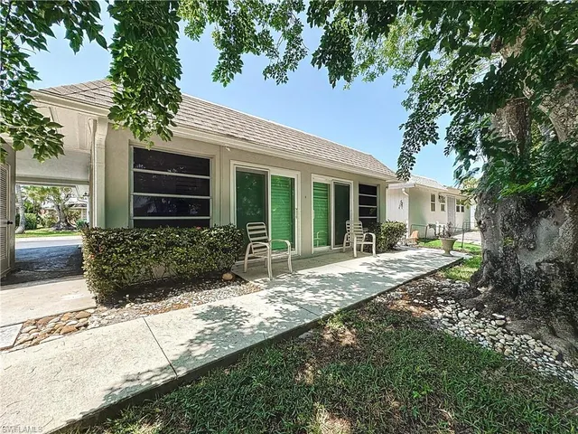 a view of a house with backyard and sitting area