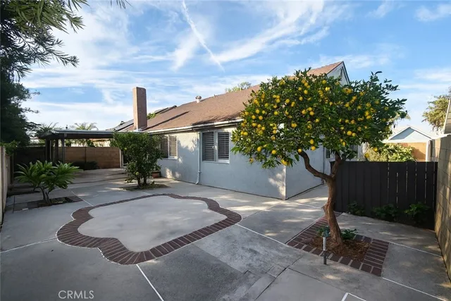 a backyard of a house with table and chairs plants