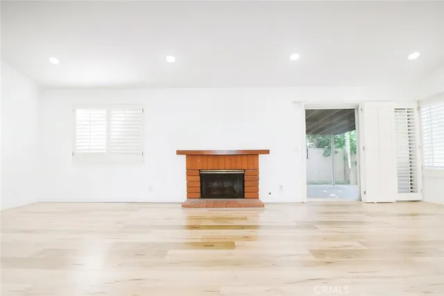 a view of a livingroom with wooden floor and a fireplace