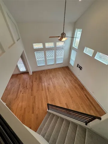 an empty room with windows and fan