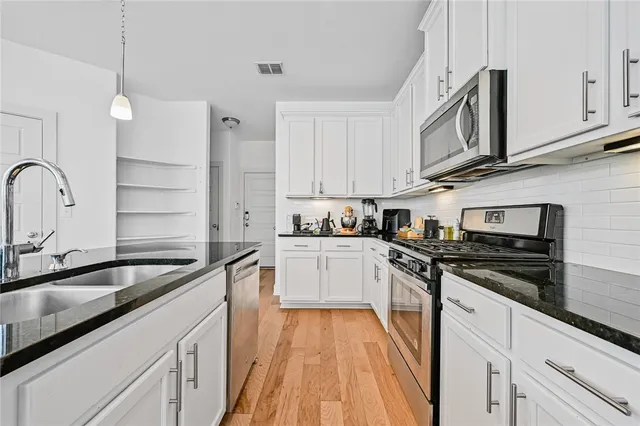 a kitchen with stainless steel appliances granite countertop a sink and cabinets
