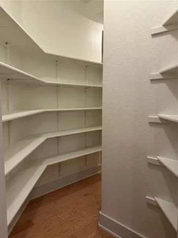 a view of walk in closet with empty racks