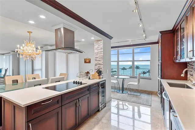 a kitchen with stainless steel appliances granite countertop a refrigerator a sink a stove and a refrigerator