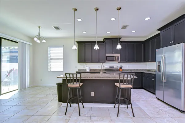 a kitchen with granite countertop a sink a counter top space appliances and cabinets