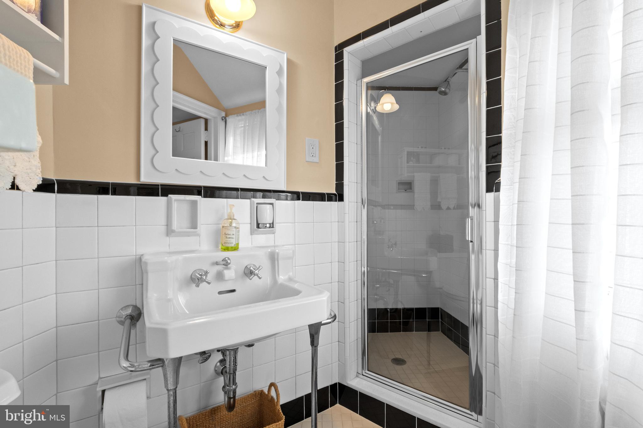 810 Merion Square Road Gladwyne, PA 19035 - Photo 18 of 32 a bathroom with a shower sink and mirror