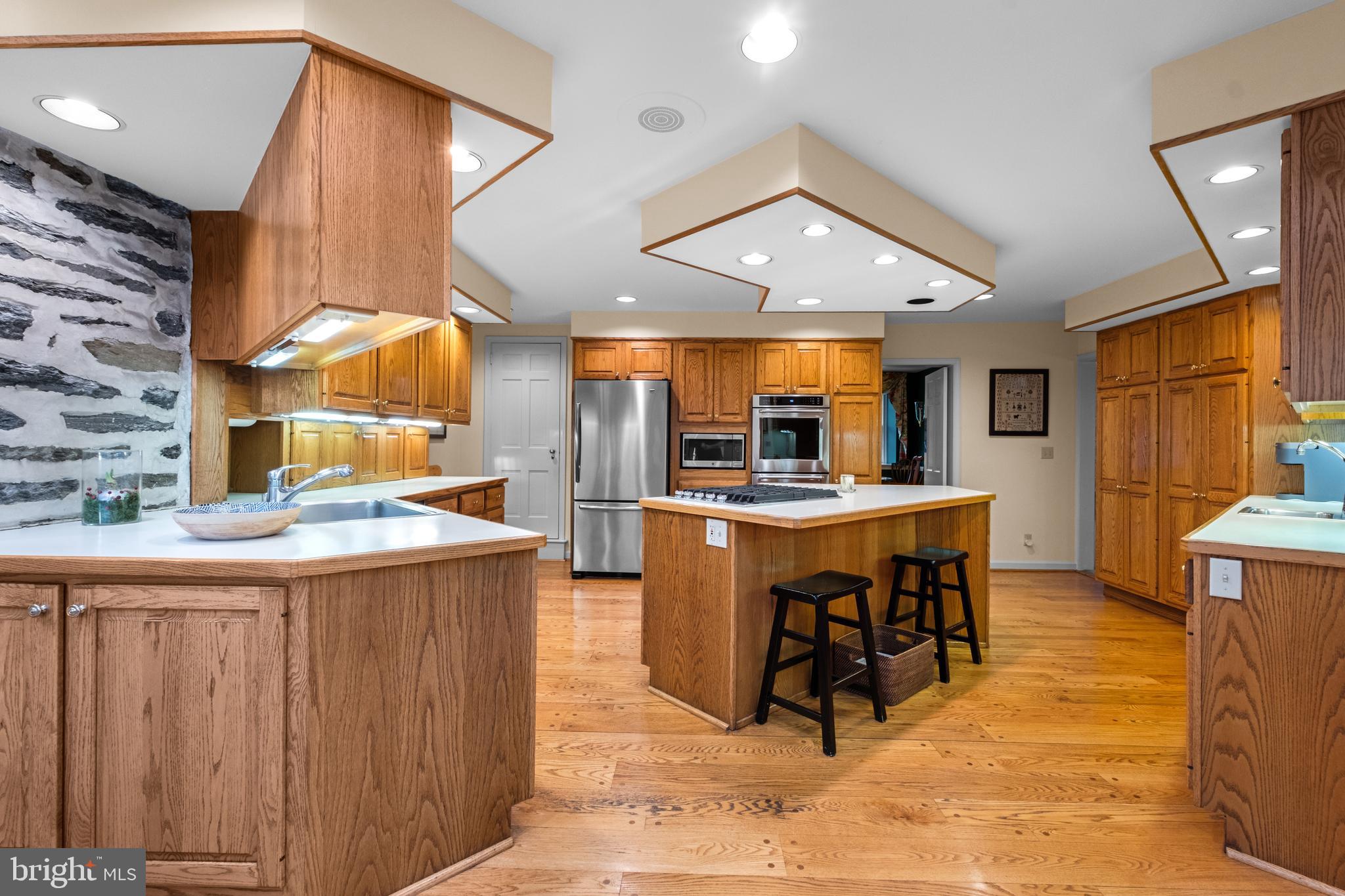 810 Merion Square Road Gladwyne, PA 19035 - Photo 8 of 32 a kitchen with stainless steel appliances kitchen island granite countertop a table and chairs in it