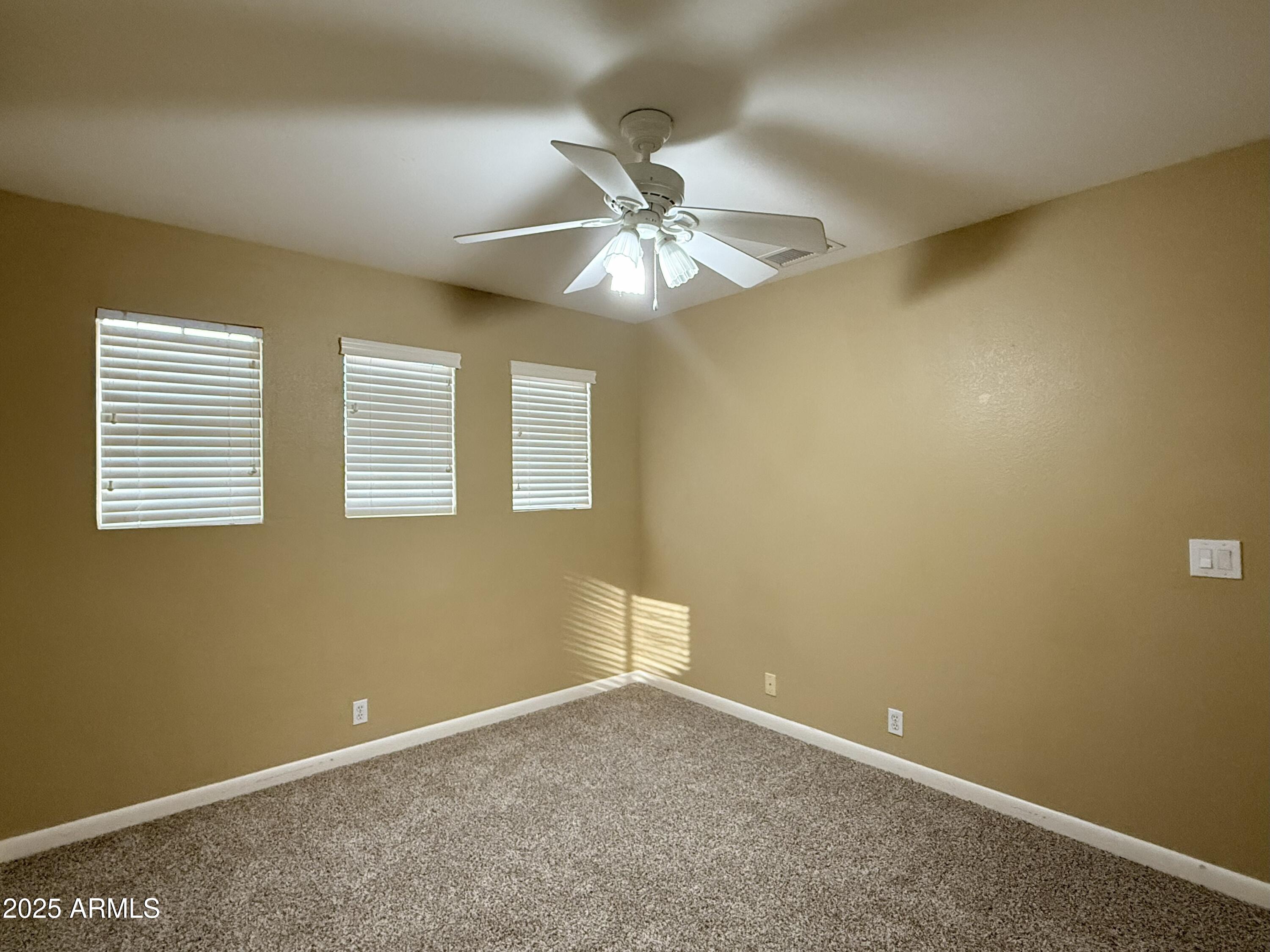 2917 East Windsong Drive Phoenix, AZ 85048 - Photo 16 of 26 an empty room with a window and a ceiling fan