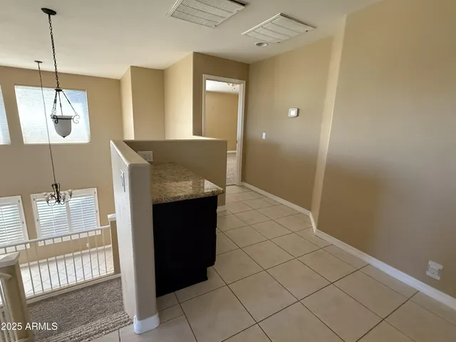 a view of a hallway with furniture and a chandelier
