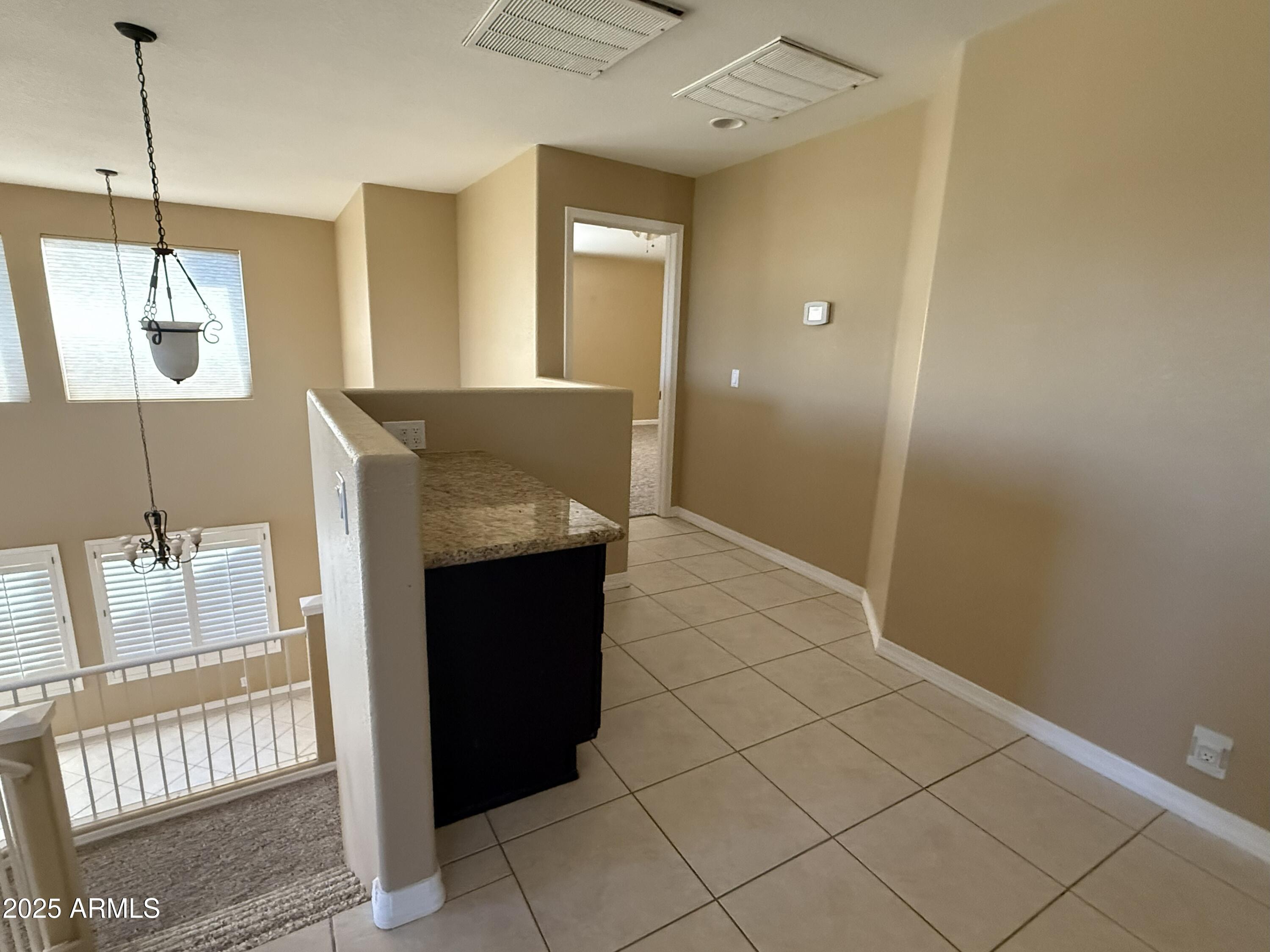2917 East Windsong Drive Phoenix, AZ 85048 - Photo 19 of 26 a view of a hallway with furniture and a chandelier