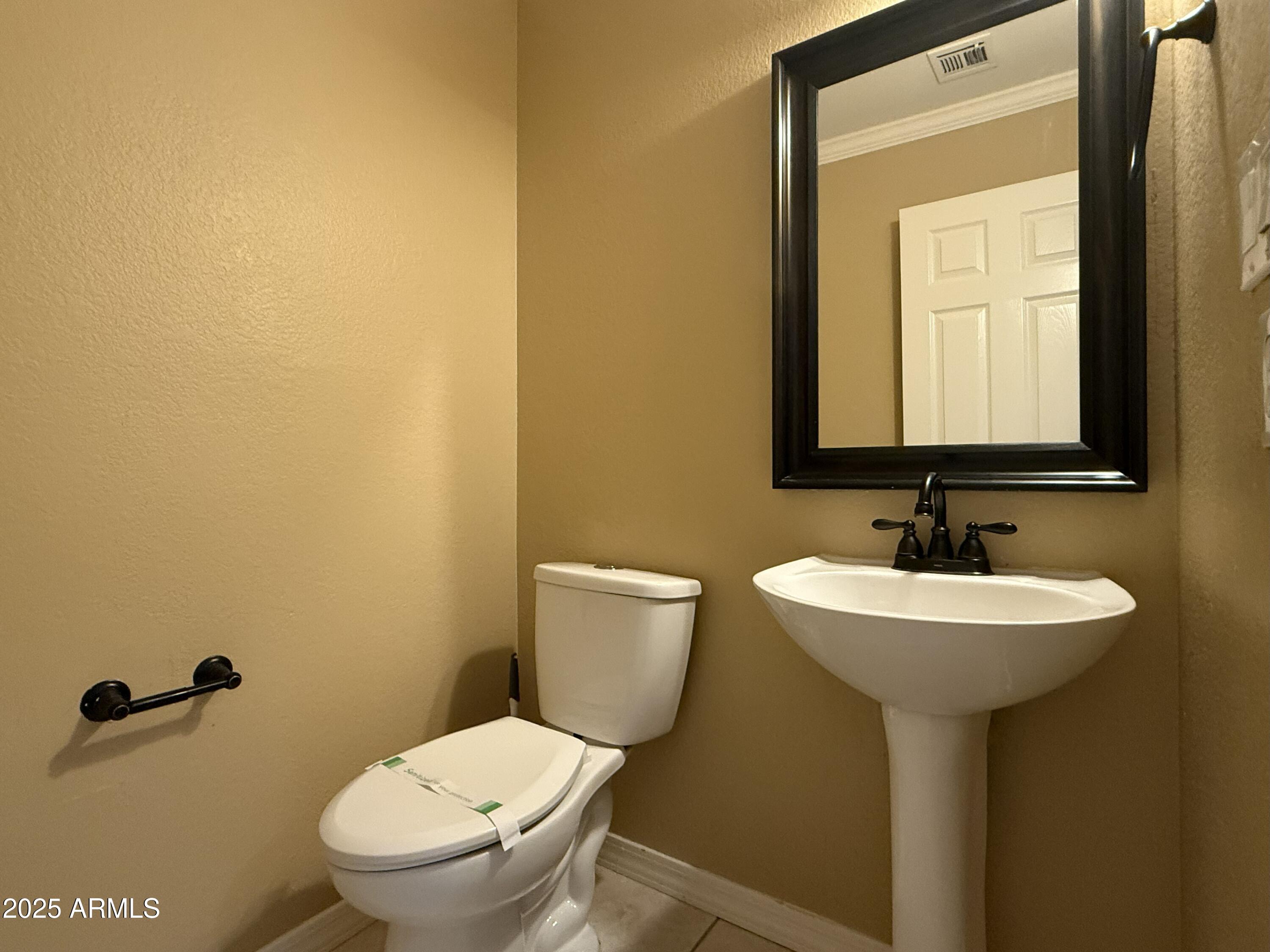 2917 East Windsong Drive Phoenix, AZ 85048 - Photo 22 of 26 a bathroom with a toilet sink and mirror
