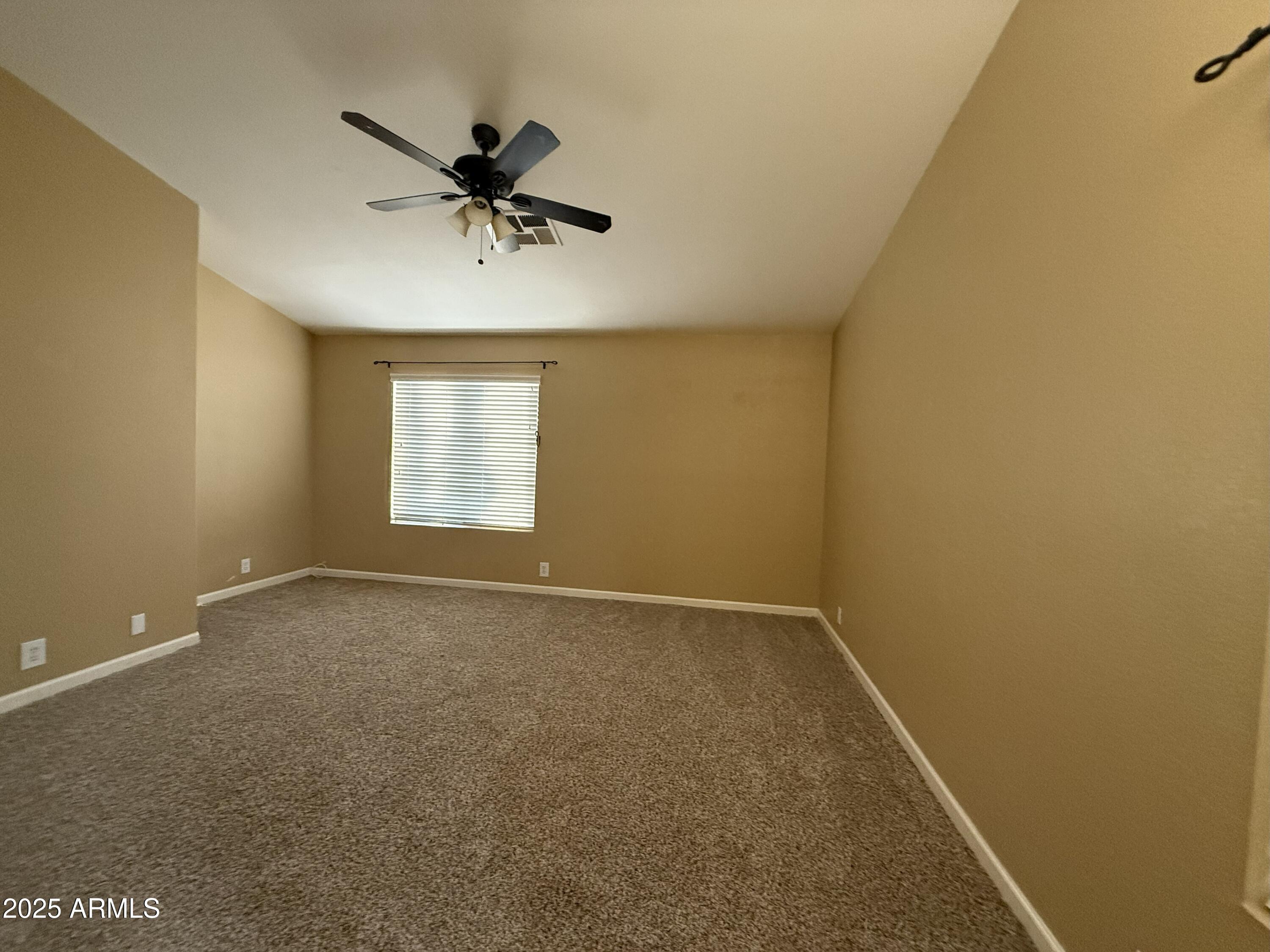 2917 East Windsong Drive Phoenix, AZ 85048 - Photo 9 of 26 an empty room with a window and a ceiling fan
