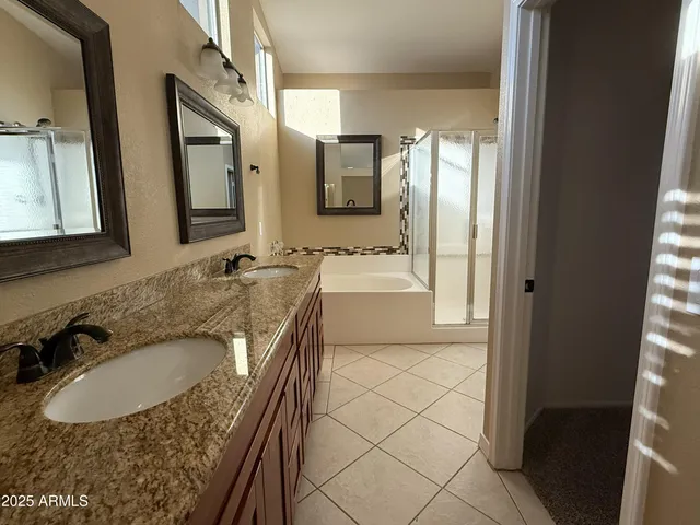 a bathroom with a granite countertop sink a mirror and a bathtub