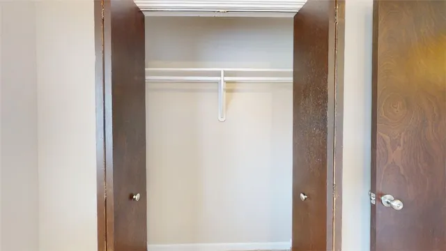 an empty room with a window and a ceiling fan