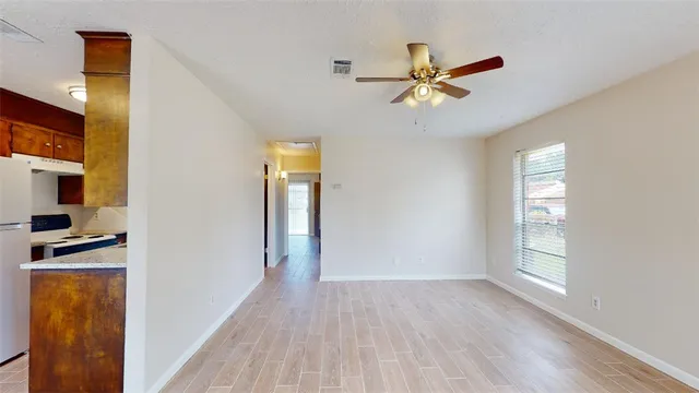 a view of a livingroom with a hardwood floor and a ceiling fan