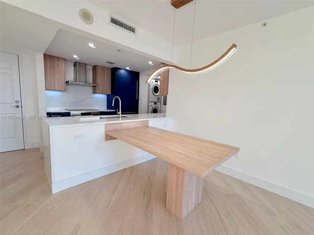 a large kitchen with stainless steel appliances granite countertop a stove a sink and a refrigerator