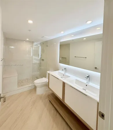 a bathroom with a double vanity sink toilet and shower
