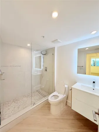 a bathroom with a granite countertop sink a toilet and shower