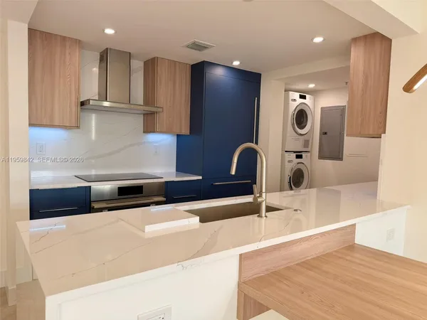 a kitchen with stainless steel appliances granite countertop a sink and a refrigerator