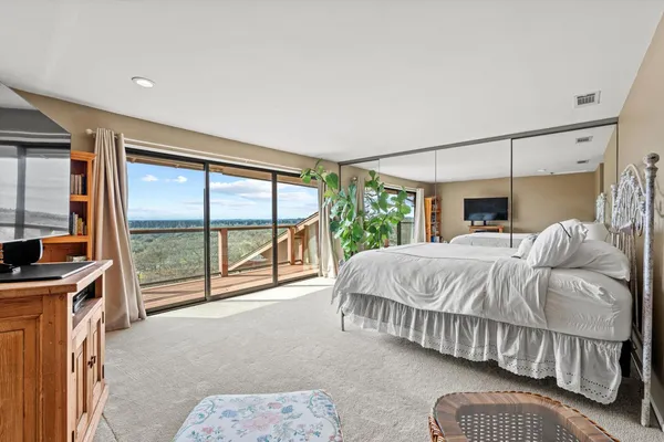 a bedroom with a bed and a large window