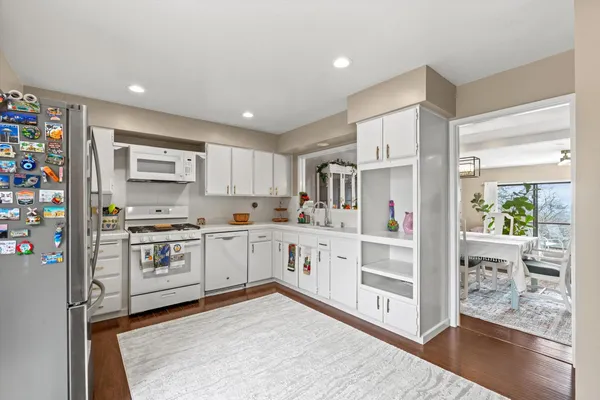 a kitchen with stainless steel appliances white cabinets and wooden floors