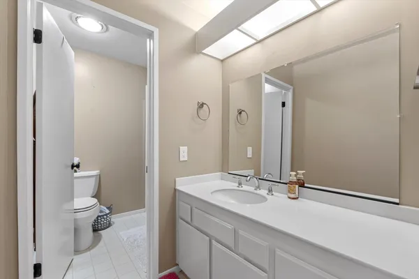 a bathroom with a sink a toilet and a large mirror