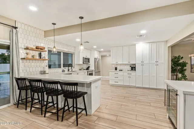 a large kitchen with stainless steel appliances kitchen island granite countertop a stove and a sink