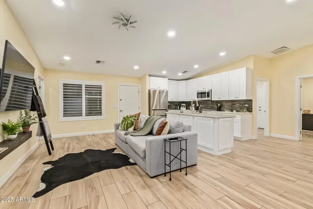 a living room with furniture kitchen and a potted plant