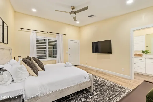 a large bedroom with a bed and wooden floor