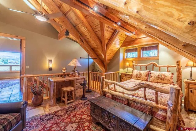 a bed sitting in a spacious bedroom next to a window