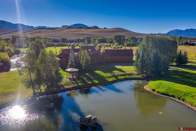 a view of a big house with a big yard and a large trees